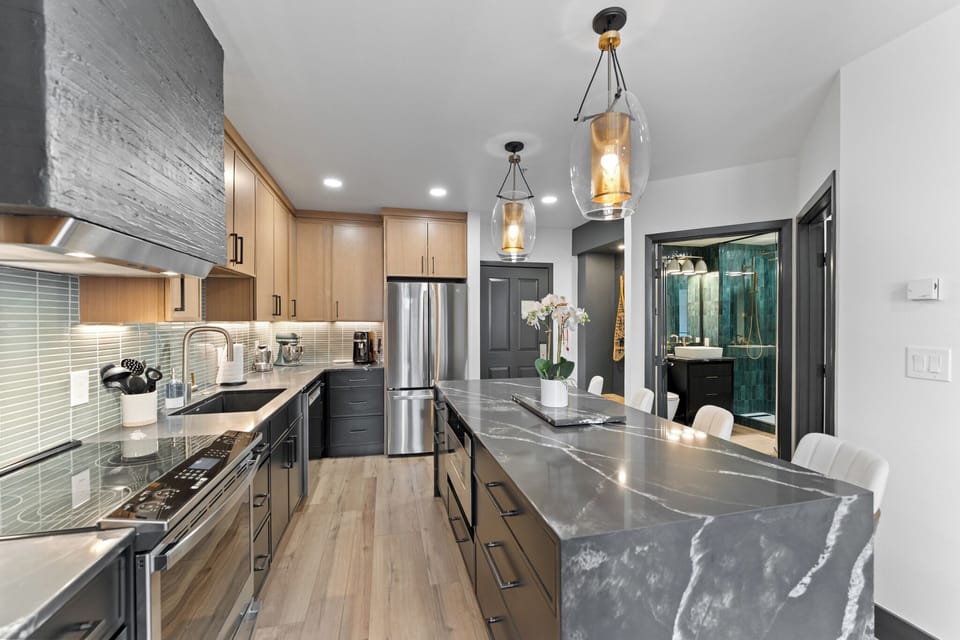 Full kitchen featuring stainless steel appliances and a breakfast bar with seating for four.