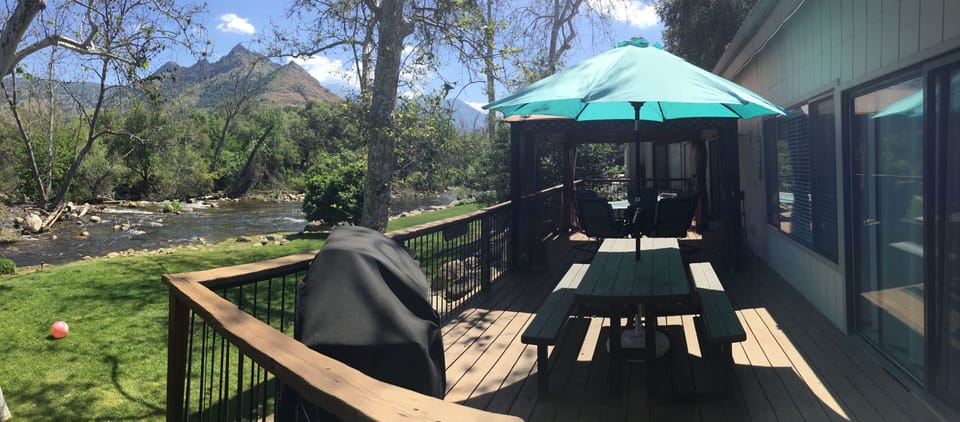 Two tables one, propane BBQ, umbrella gazebo with mosquito netting
