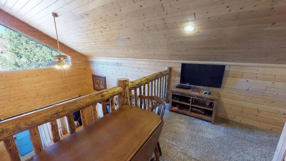 Upstairs loft with an entertainment center with a tv.