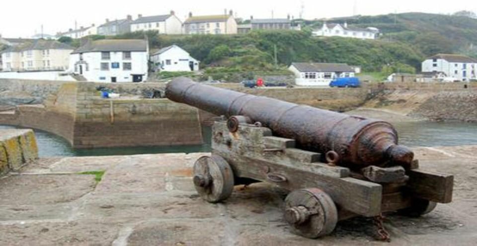 Cannon from shipwreck frigate HMS Anson 1807 points across Porthleven Harbour