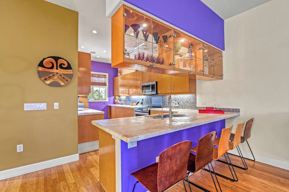 A bright, fully equipped kitchen with sleek breakfast bar seating—perfect for morning coffee or casual bites before the beach.
