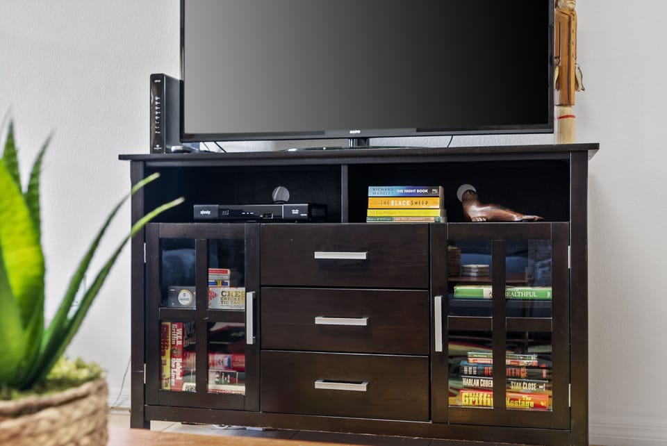 Family room TV with storage for Wi-Fi,  books and games.