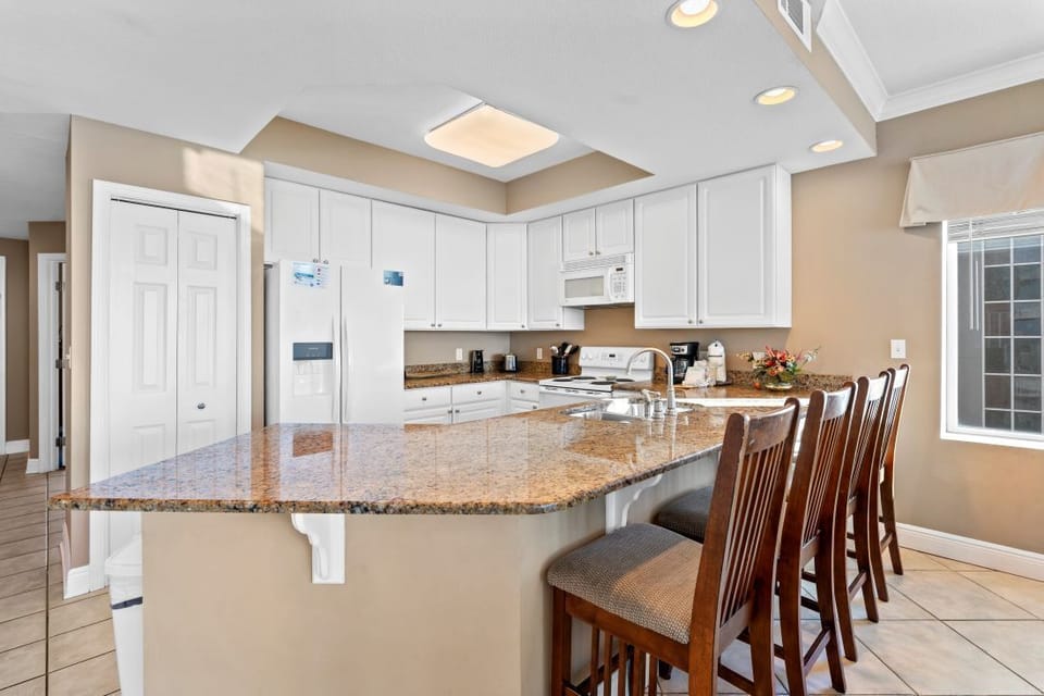 Gather around your spacious granite island for morning coffee or evening conversations in this bright, fully-equipped kitchen with modern appliances.