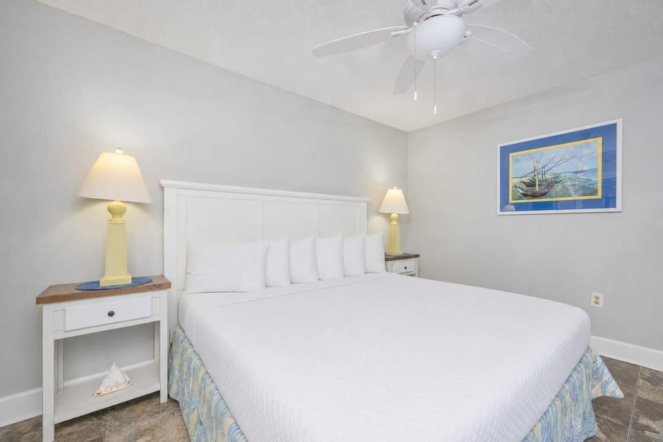 Relax on the king bed in this guest room, surrounded by soft linens and vibrant coastal decor