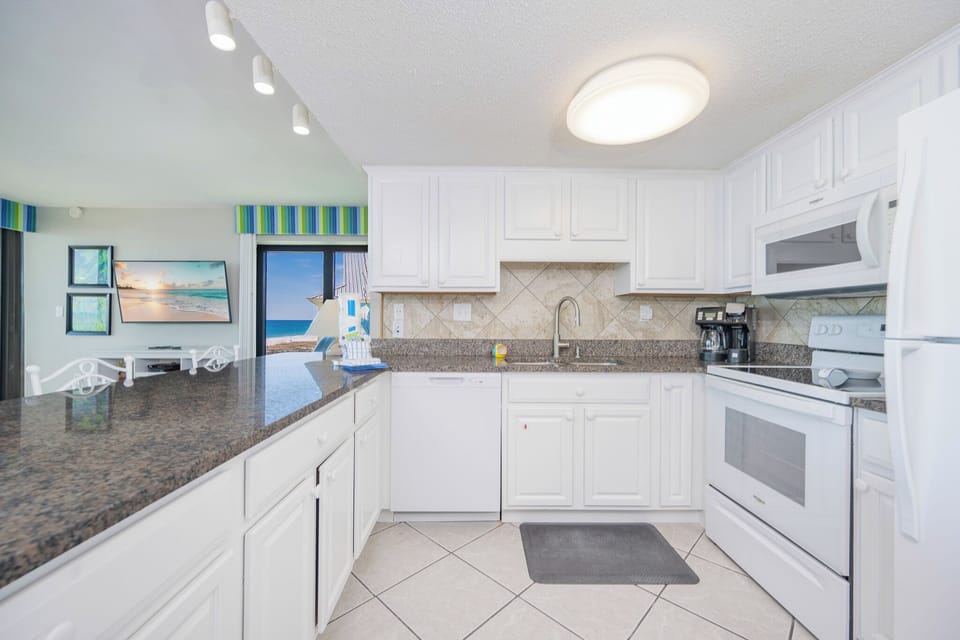 Prepare your favorite meals in this inviting kitchen while enjoying views of the coast through the open sliding door