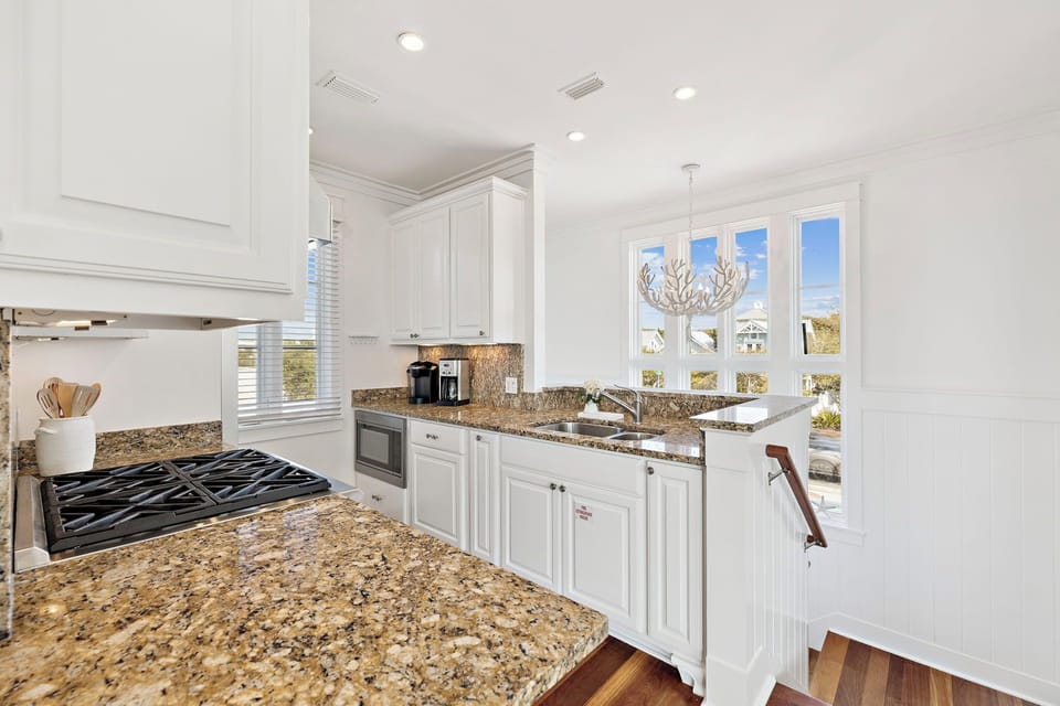 Your gourmet kitchen awaits with granite counters, white cabinetry, and gas cooking—perfect for preparing memorable meals together.