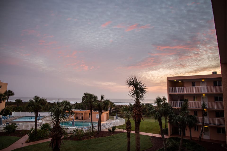 Beautiful sunset casts its rays on sky outside our window! Note view and pools!