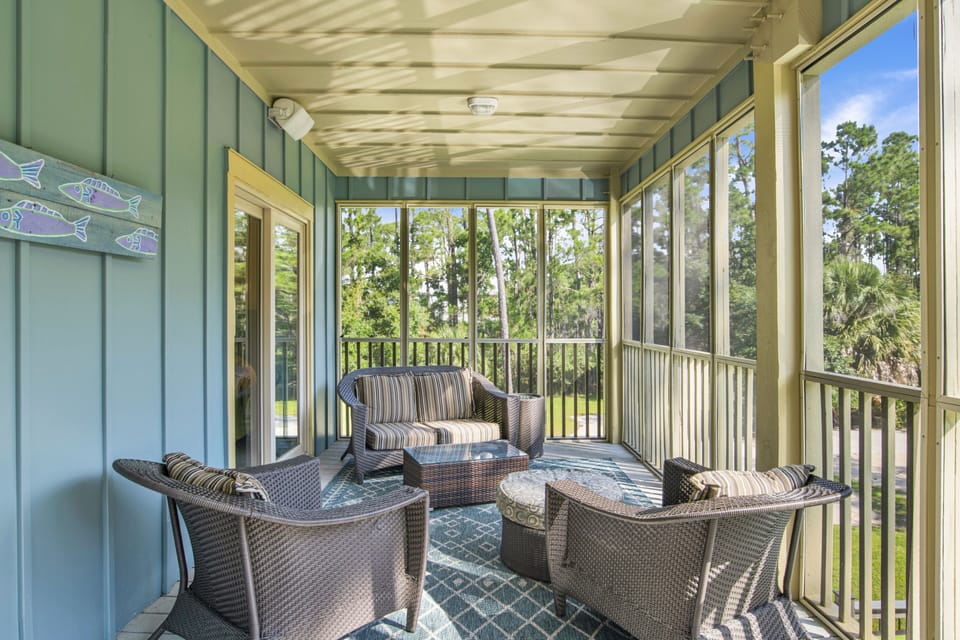 Rear screened porch overlooks the pool and backyard