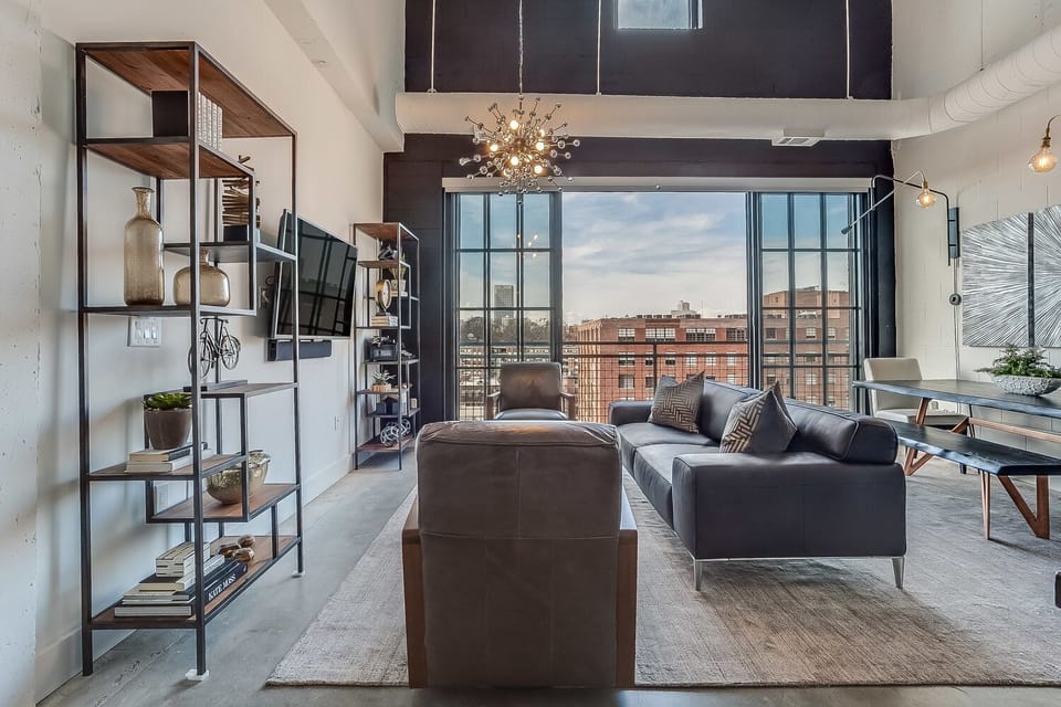 Living Area with Sofa, Arm Chairs, Dining Set, TV, and Lamps.