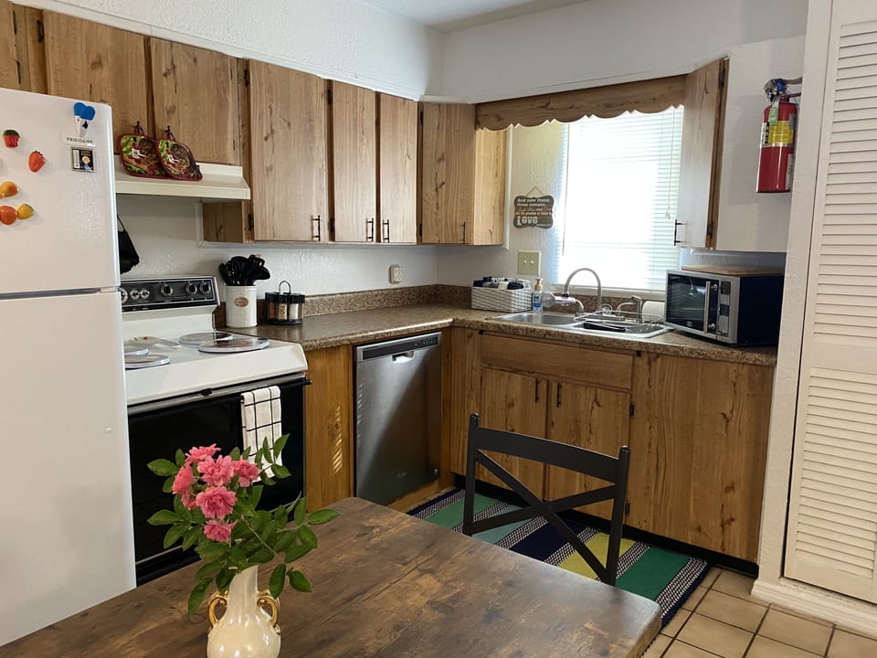 kitchen area with dishwasher, stove, refrigerator, microwave