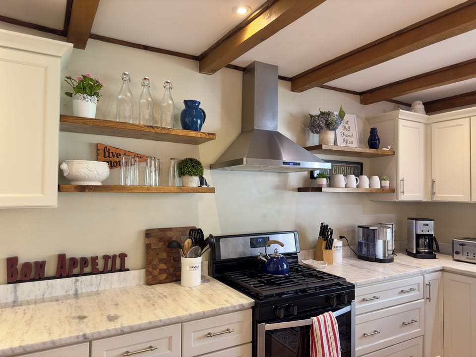 A fully stocked cook's kitchen with two types of coffee makers, espresso machine
