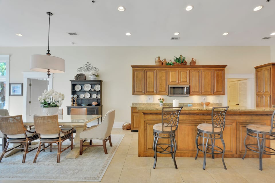 Kitchen and Dining Area - Granite counters, stainless appliances, bar seating, and nearby dining table support meals in the main living space.