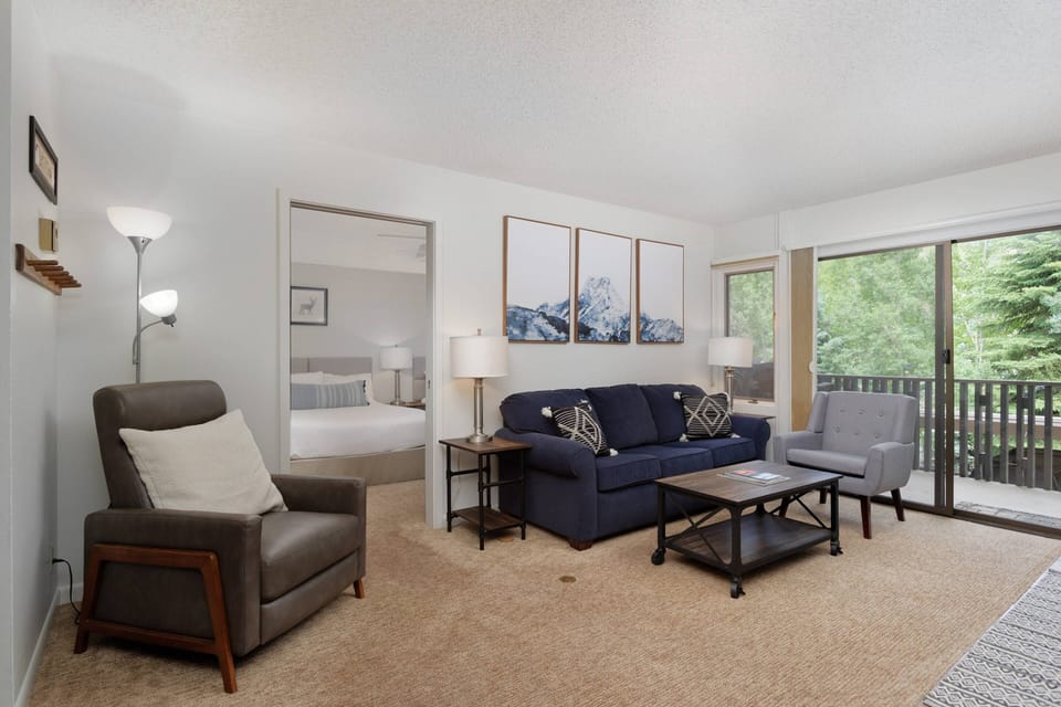 A spacious and comfortable living area flows into a large bedroom with 2 queen beds.
