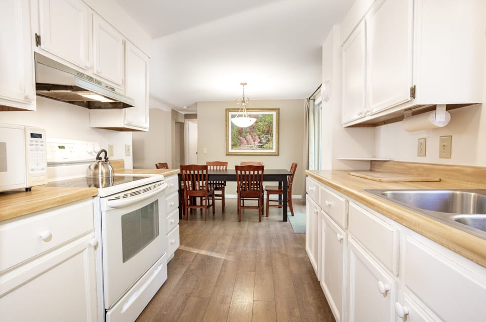 Dining table with slider to back deck. Grill outdoors, well-equipped kitchen.