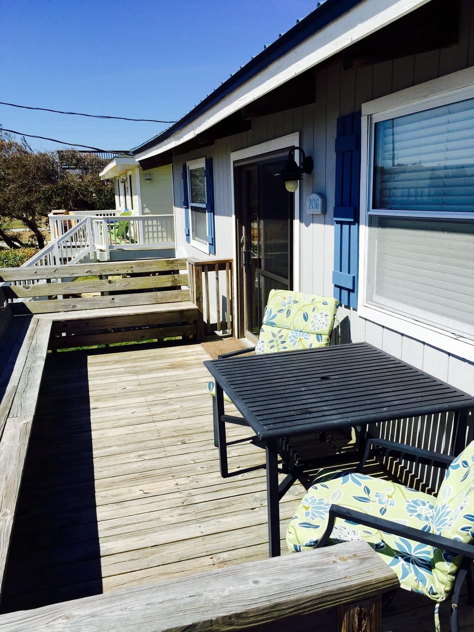 Deck on front of house with bench seating all around.