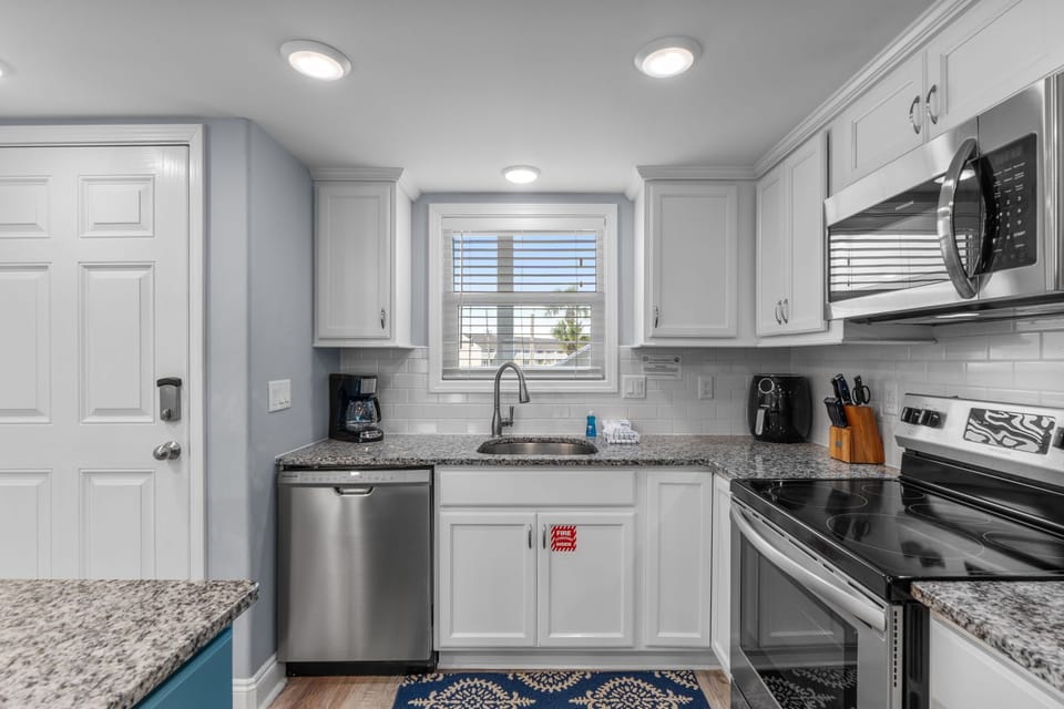 Your spacious kitchen features granite countertops, stainless steel appliances, and everything needed to prepare meals during your stay.
