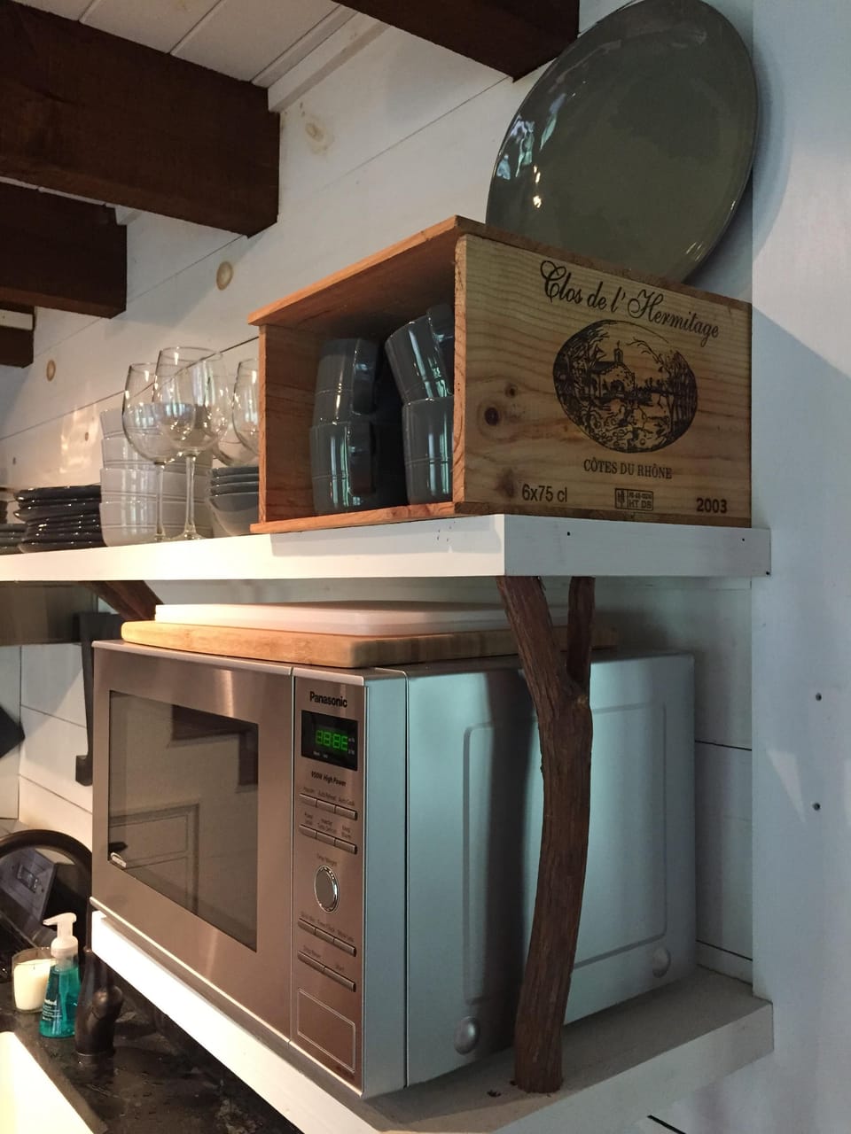 Rustic laurel supports hold modern appliances and hand thrown dinnerware. 