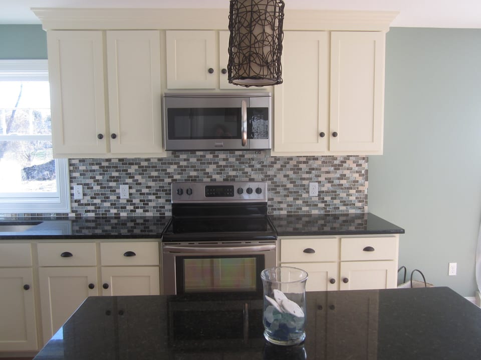 Kitchen with custom tile work and stainless steel appliances.