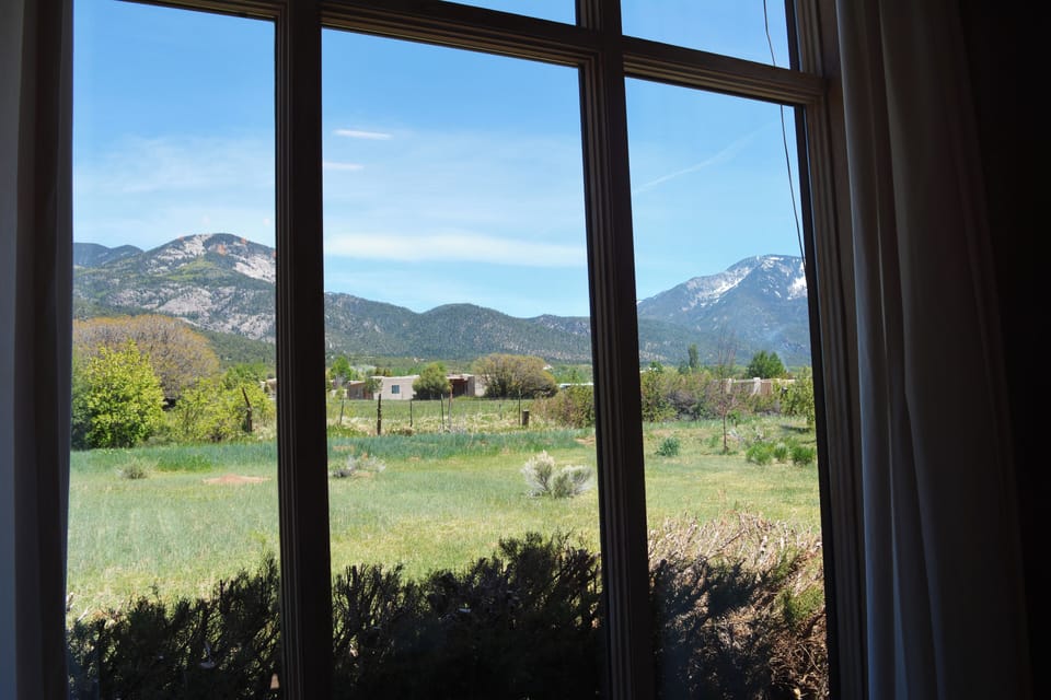 Close up view of Taos Mountain background and horse / cow pasture from living room round table.