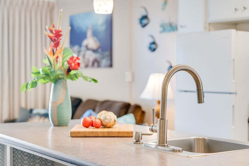Inviting kitchen counter accented with tropical blooms and a tidy prep board for a welcoming feel