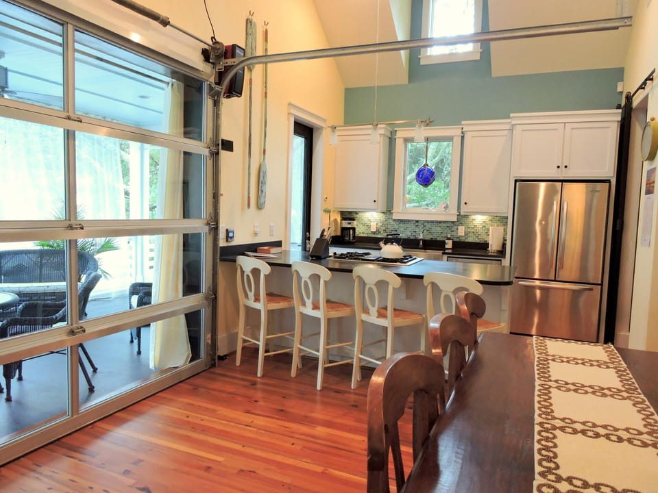 High-end kitchen with dining room that opens to the porch through garage doors