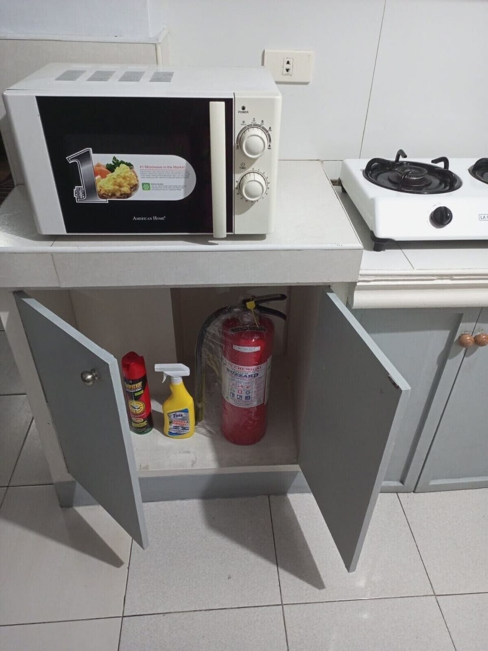 Home has a fire extinguisher, stored in the kitchen cabinet, close to gas stove.