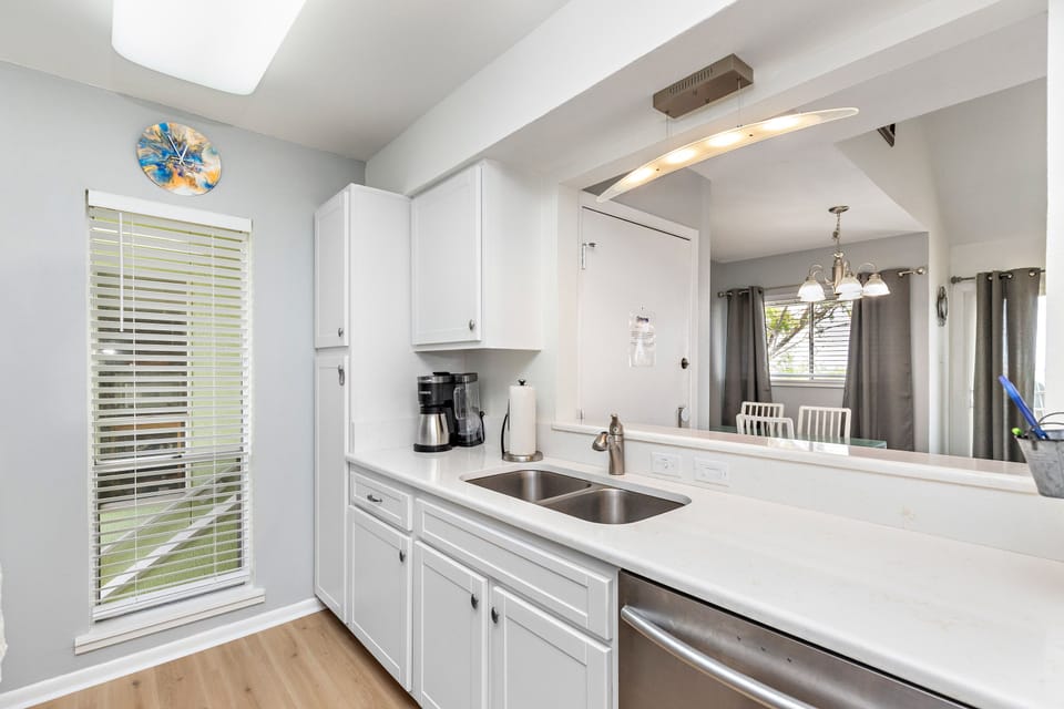 Cook your favorite meals in this bright, modern kitchen with pristine white cabinets, sleek countertops, and all the essentials you need.