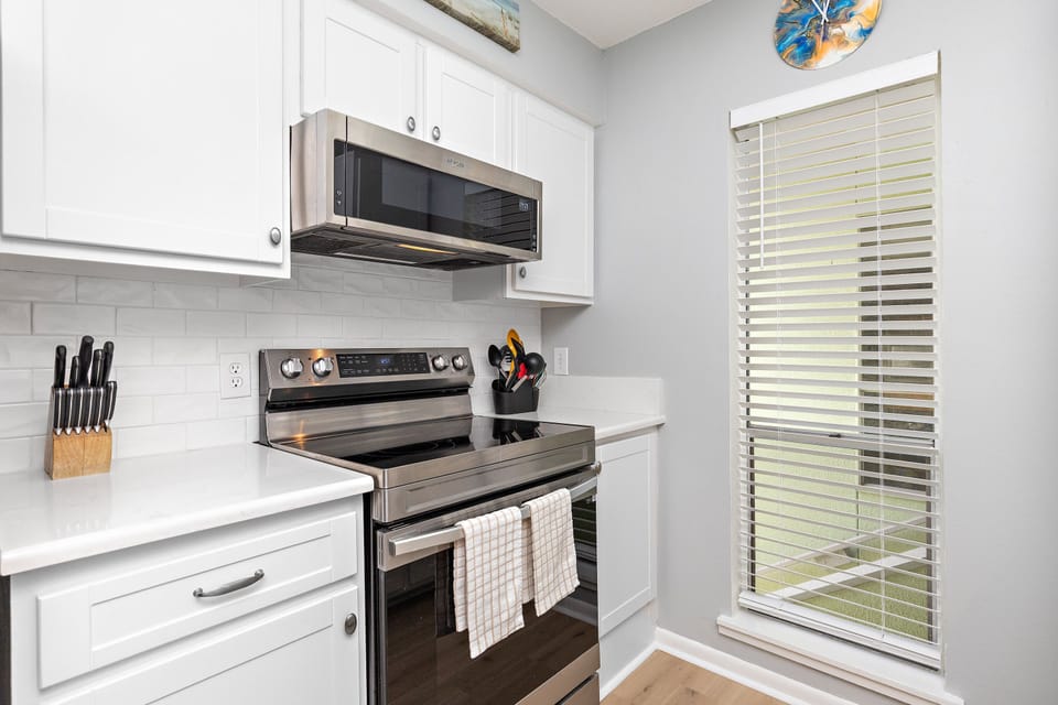 Your bright kitchen features modern appliances and crisp white cabinetry, perfect for preparing meals during your stay.