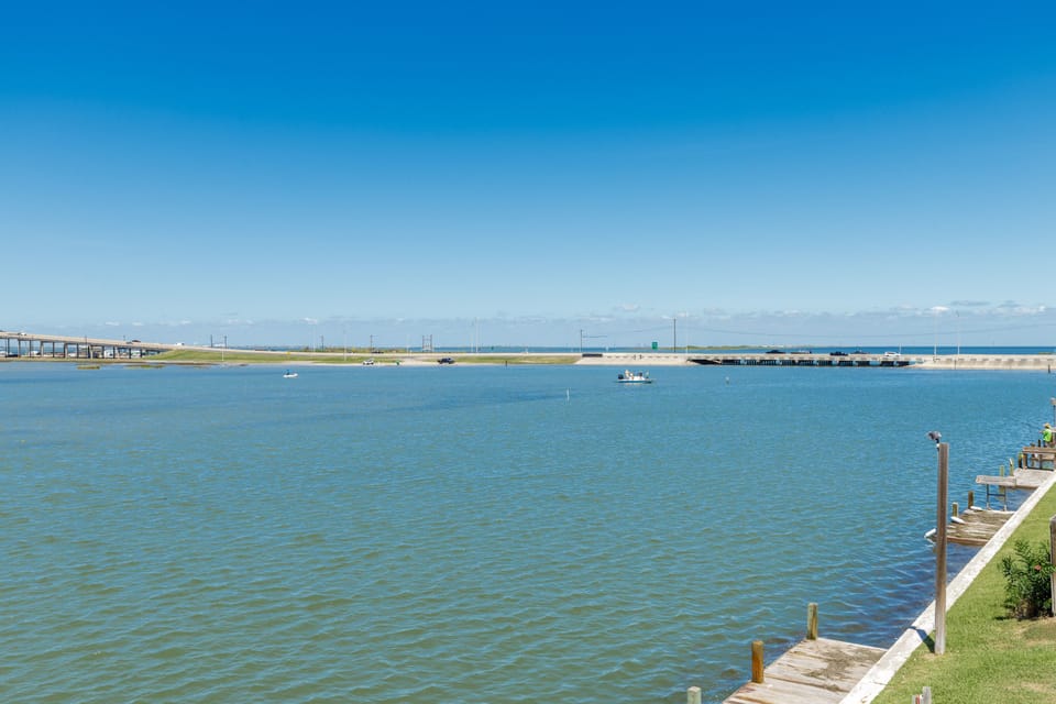 Peaceful waterfront setting with pristine bay waters, distant bridges, and serene boating atmosphere under clear blue skies.