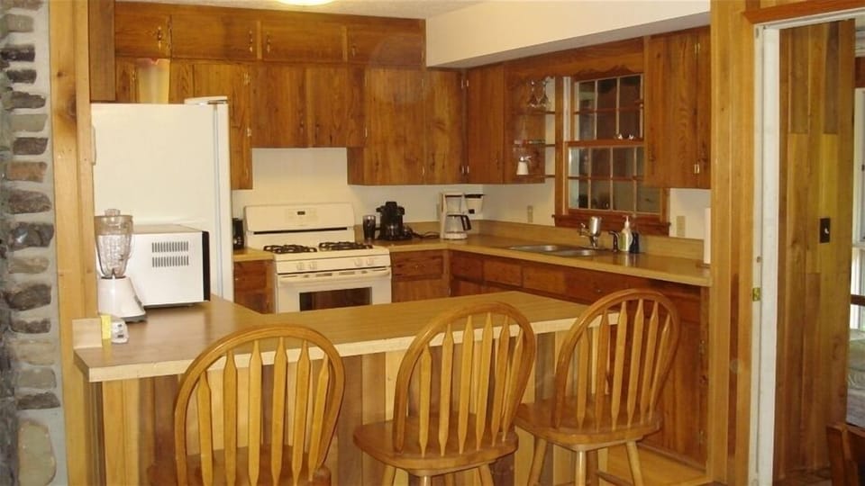 Wormy chestnut custom cabinets and maple floors warm the well-appointed kitchen