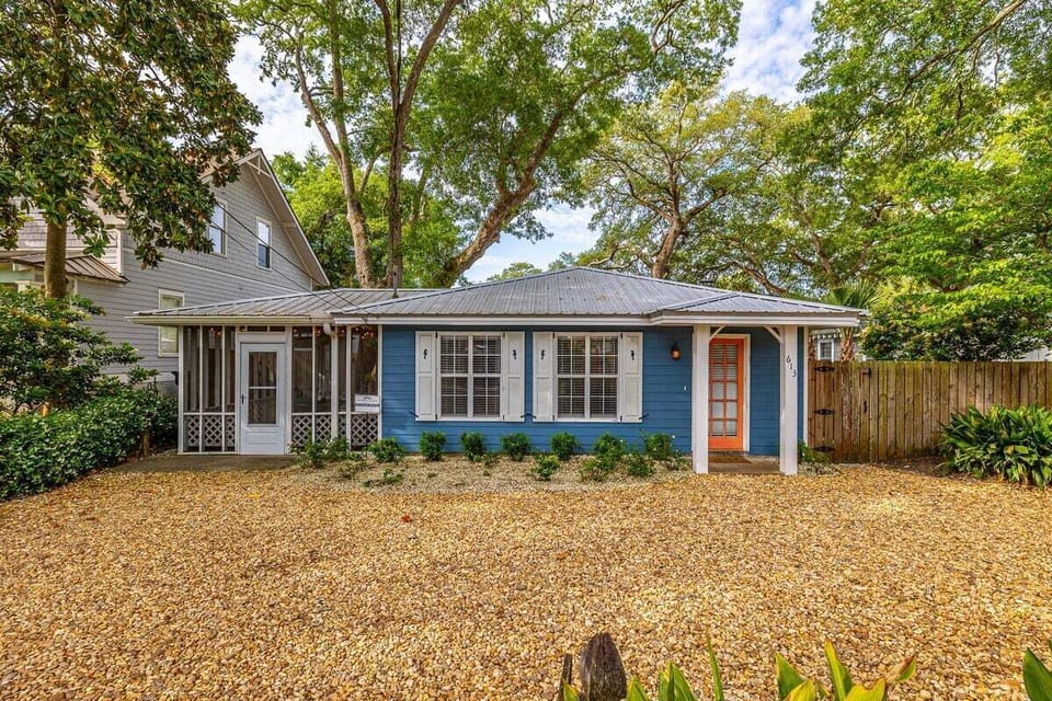 Front exterior with orange door and gravel yard