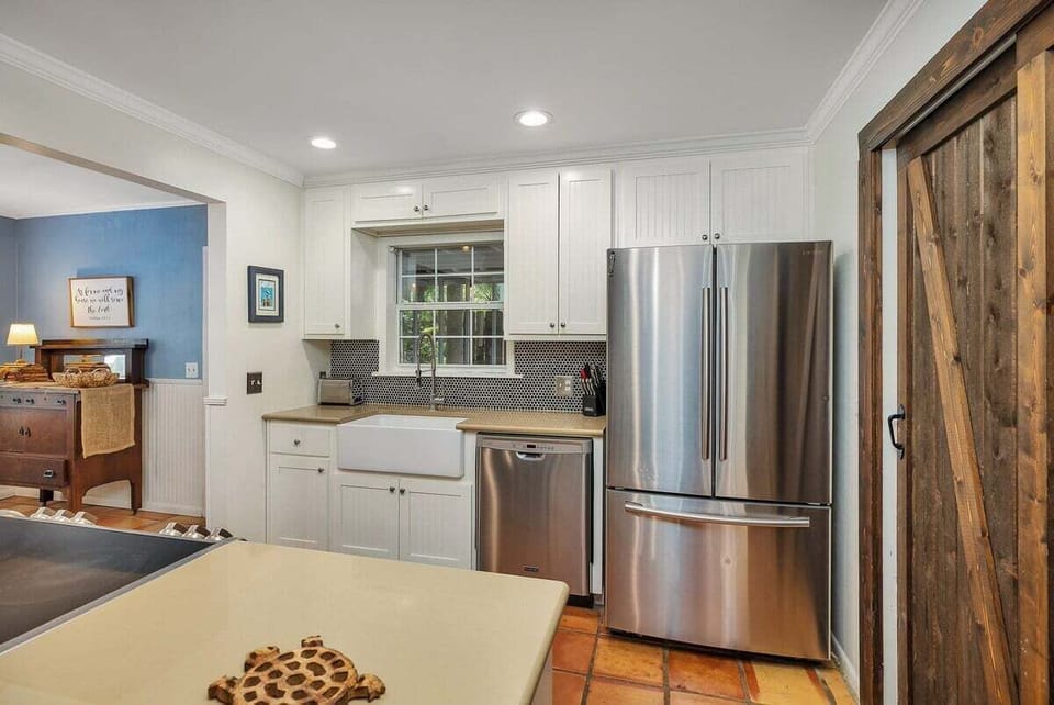 White kitchen with farmhouse sink and stainless appliances