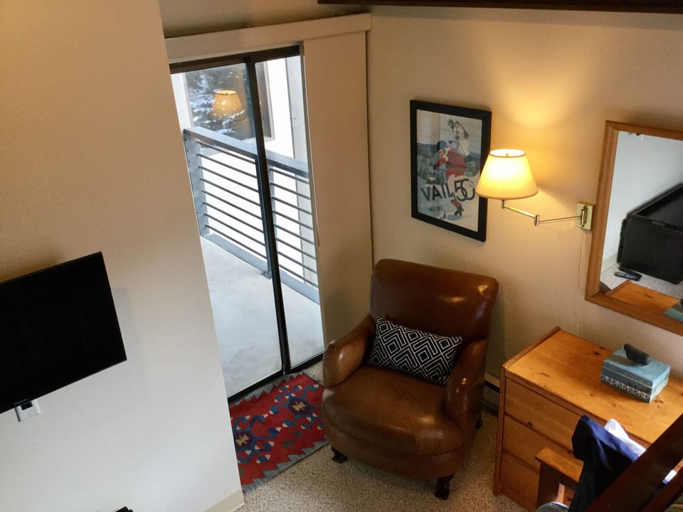 The Downstairs Bedroom has a wall TV with 100+ channels and a shared balcony.
