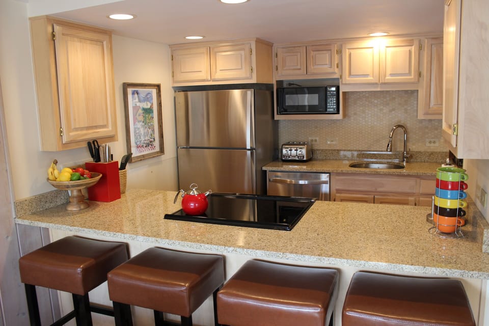Updated Kitchen has granite countertops, tile, and stainless steel appliances.