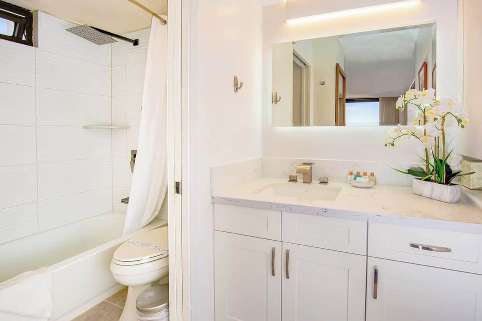 Bathroom with tub and shower combo. Sliding door separates the toilet and sink