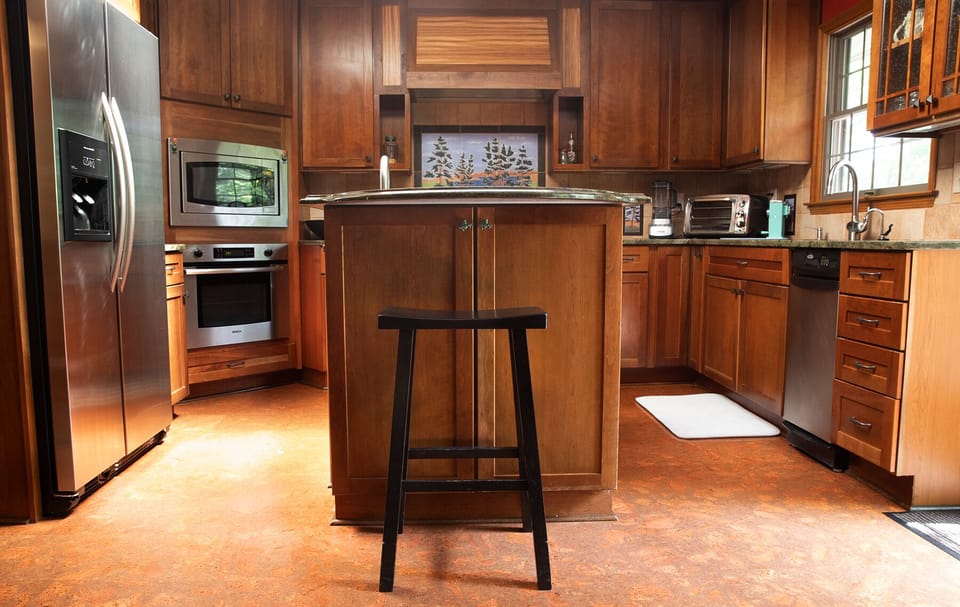 Kitchen with cork flooring, granite counters, and a skylight right off the deck
