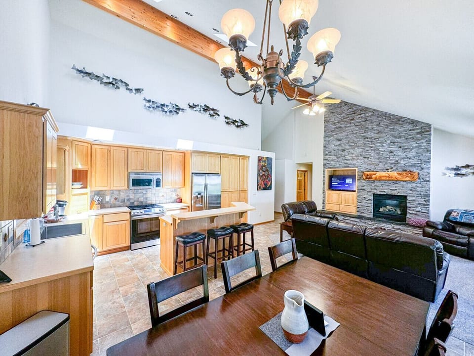 Welcome to the heart of the home! This stunning space features soaring vaulted ceilings adorned with locally sourced materials and unique artwork, creating a warm and inviting atmosphere. The dining table comfortably seats 6, while the kitchen bar offers