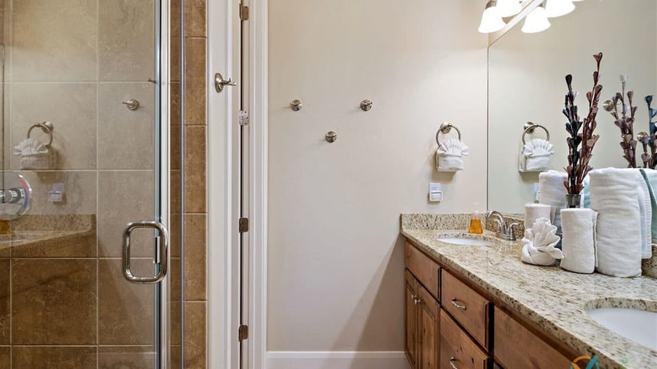 Main level master  bath featuring dual sinks and walk in shower