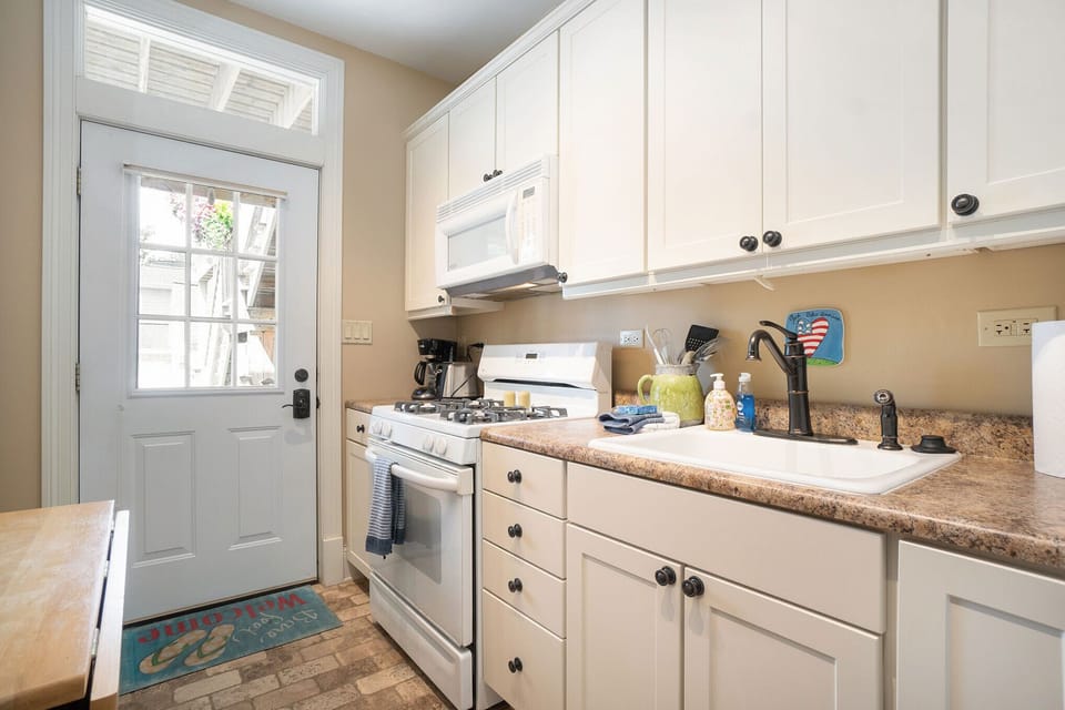 Kitchen with natural gas range and space saver microwave above. 