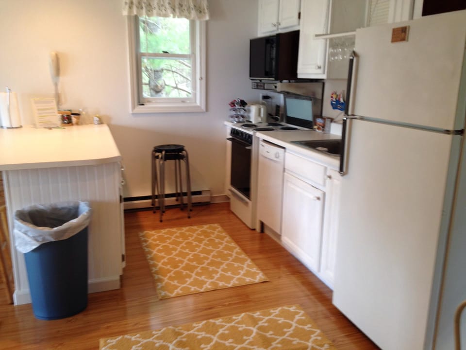 Kitchen with refrigerator, stove, microwave, coffee maker, toaster, dishwasher.