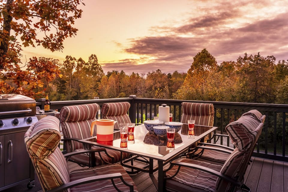 Large deck with propane grill and patio set. Basketball court and field in view