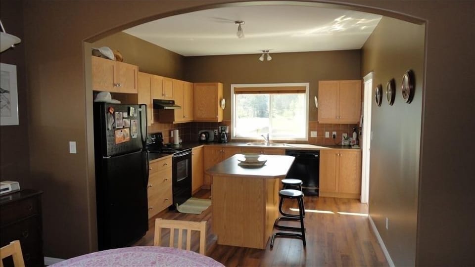 Kitchen with island with access to back deck with mountain view.