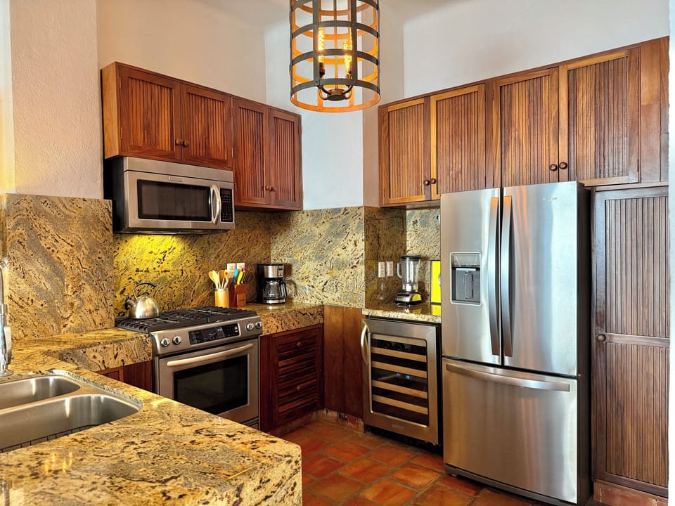 Nicely remodeled kitchen with barstools, stainless appliances & wine fridgem