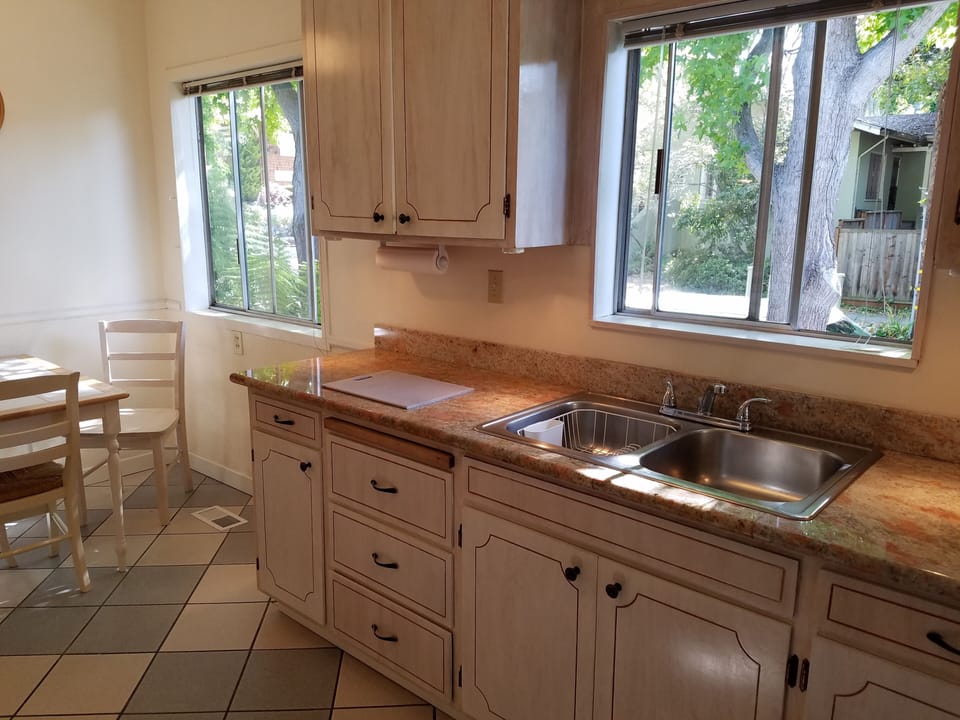Ample counter space for food prep. Dishes, cutlery, and glassware to serve four.