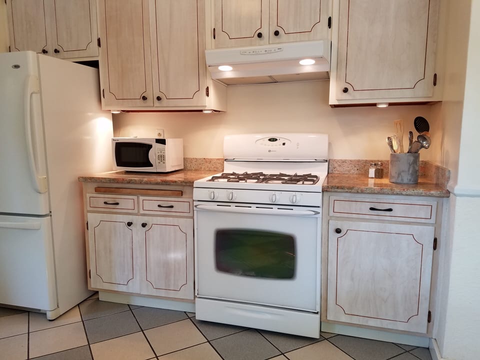 Gas stovetop & oven. Kitchen equipped with pots, pans, baking dishes, utensils.