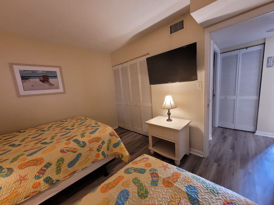 2nd bedroom with twin bed and queen bed.  Smart TV and extra chest inside closet