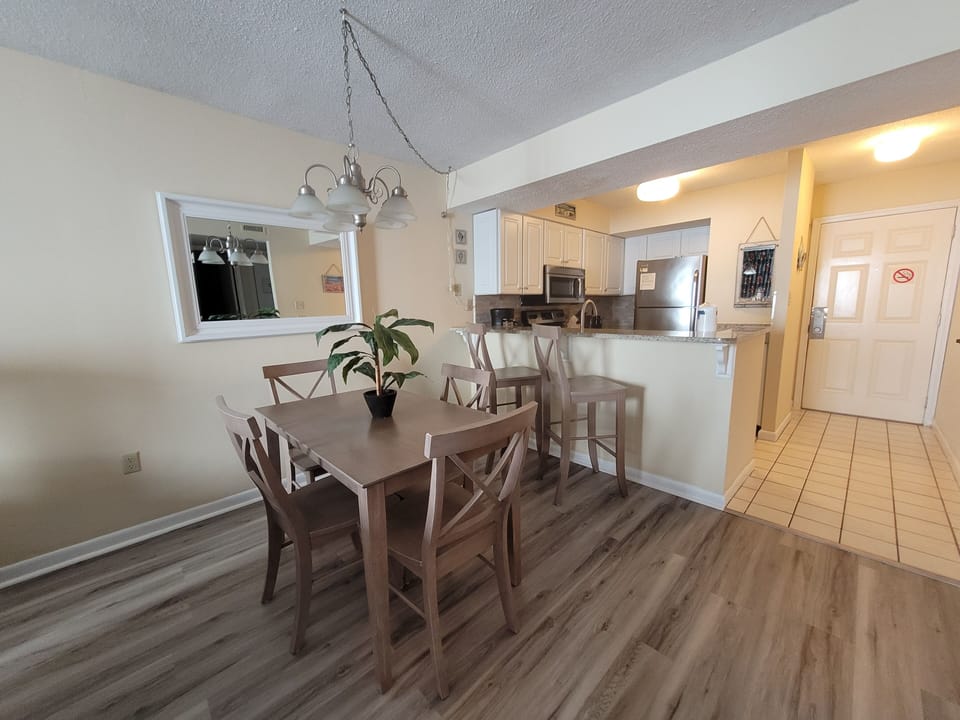 Updated vinyl plank flooring, new dining table, four chairs and two bar stools.