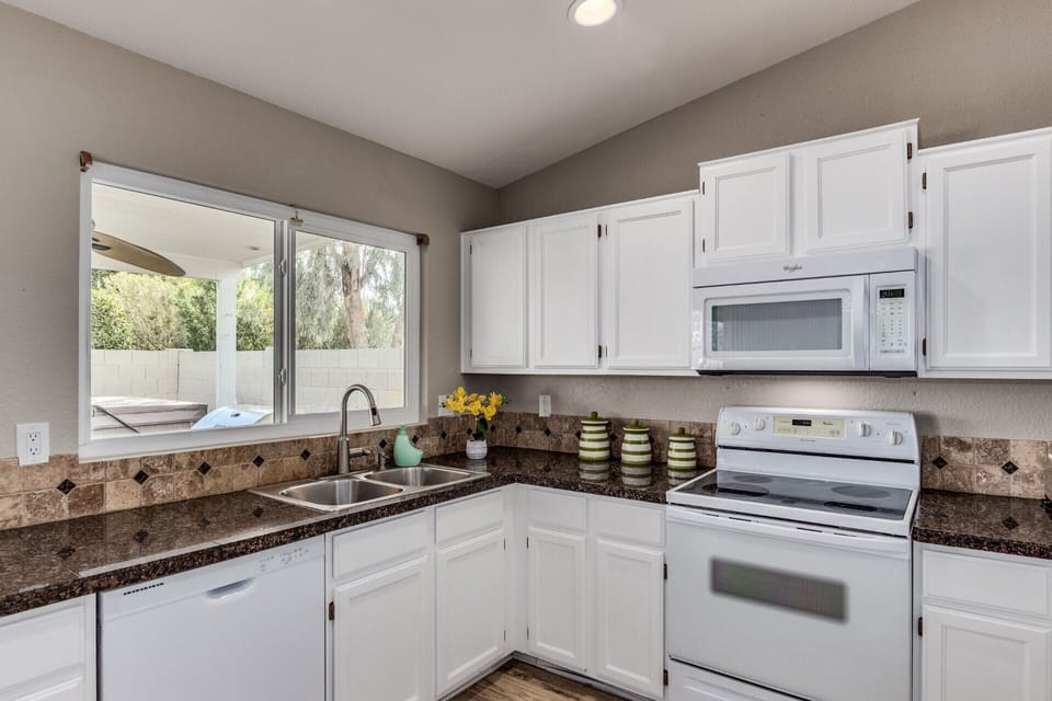 Well stocked kitchen with coffee maker, toaster oven, blender, spice rack & more