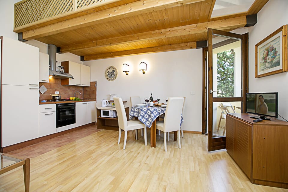 The living room with dinner table and view of the kitchen