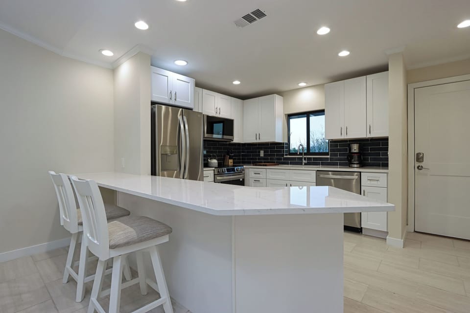 Kitchen with stainless steel appliances and breakfast bar